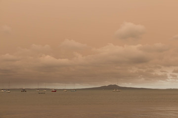 A haze from Australia's bushfires hangs over Torbay Beach, North Shore district of Auckland, New Zealand.