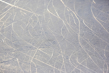 bright traces of ice skating on an ice rink. background and texture