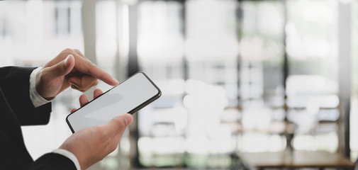 Close-up view of young professional businessman using smartphone