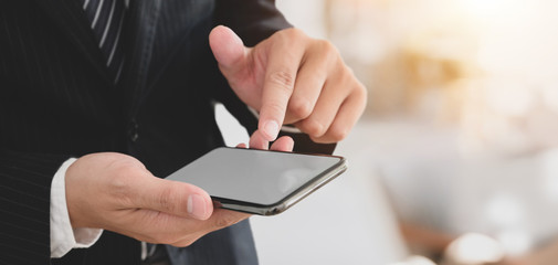 Close-up view of young professional businessman using smartphone