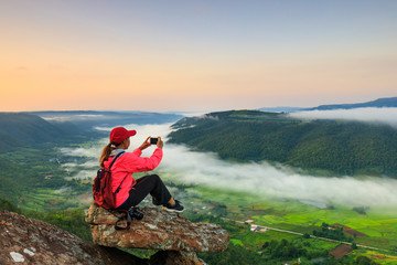 Obraz premium The girl in red jacket touring on the mountain, Phu-E-Lerd, Loei province, Thailand.