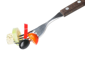 Fork with tasty Greek salad on white background