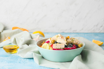 Bowl with fresh Greek salad on table