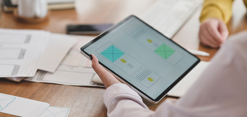 Close-up view of young  ui web designer working on her concept with tablet