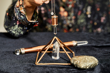 A Spiritual Healer using a Crystal Pendulum over a Pyramid - obrazy, fototapety, plakaty