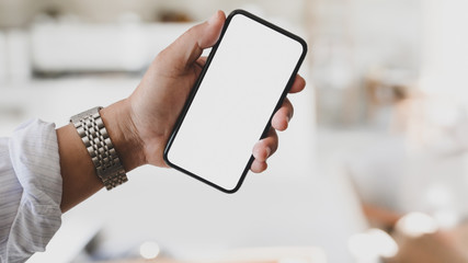 Cropped shot of young man holding blank screen smartphone