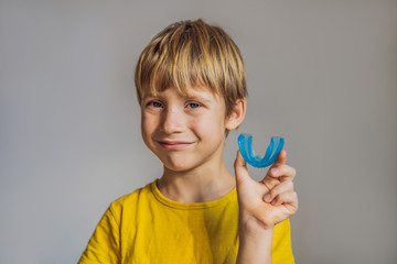 Six-year old boy shows myofunctional trainer. Helps equalize the growing teeth and correct bite, develop mouth breathing habit. Corrects the position of the tongue