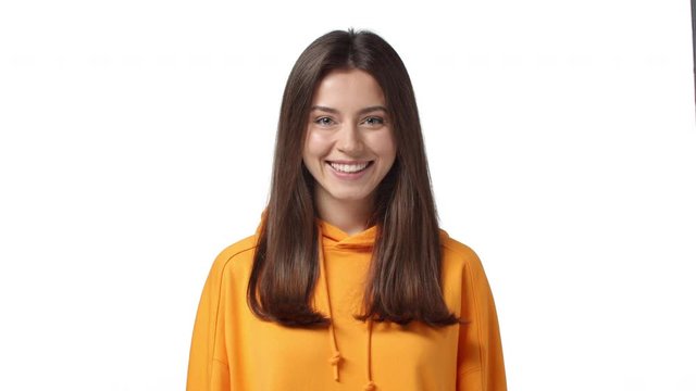 Valentines day, relationship and women concept. Slow-motion adorable, lovely wonderful woman with silly smile, chuckle blushing shy and gazing camera flirty, standing coquettish white background
