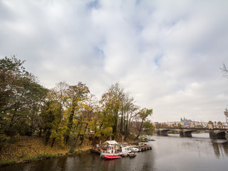 Fototapeta premium Panorama of the Old Town of Prague, Czech Republic, with focus Prague Castle (Prazsky hrad) seen from the Vltava river in autumn. The castle is the main touristic landmark of the city