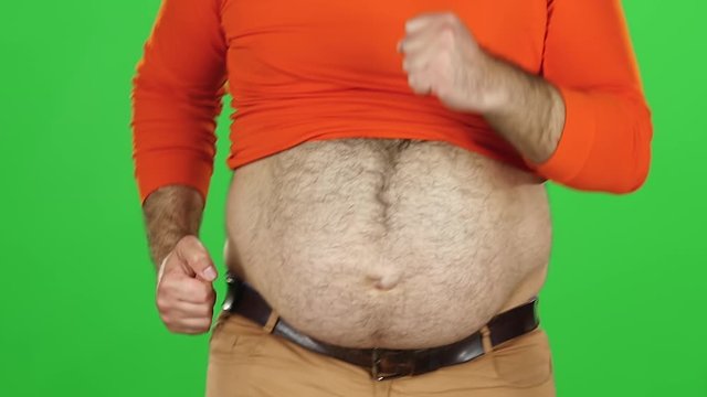 Big hairy belly of a man, close up shot. His bare belly is jiggling as he running, green screen. Slow motion
