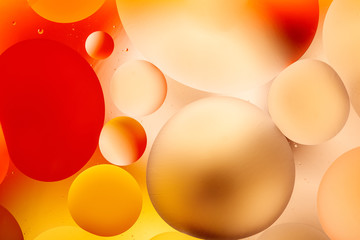 bright oily drops in water with colorful background, close-up 