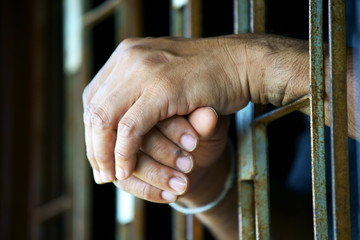 close up of prisoner hands in jail