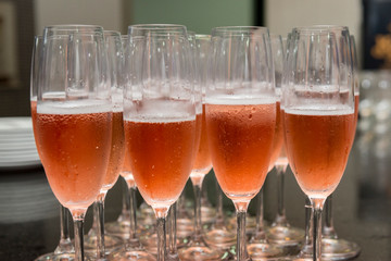 Lined crystal flutes filled with champagne on black granite counter for gold anniversary celebration. Toast of the 50 years of marriage. Golden wedding.