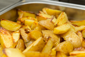 Closeup of sliced and baked rustic potatoes. Tasty dish to be served at dinners and celebrations.
