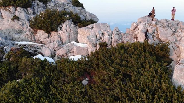 Mann geht entlang einer Felswand zum Gipfel zu den anderen Wanderern slow motion