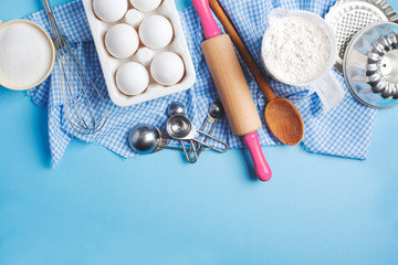 Baking background frame. Preparation for Easter baking. Ingredients and kitchen items for baking. Kitchen utensils, flour, eggs, sugar. Top view, copy space