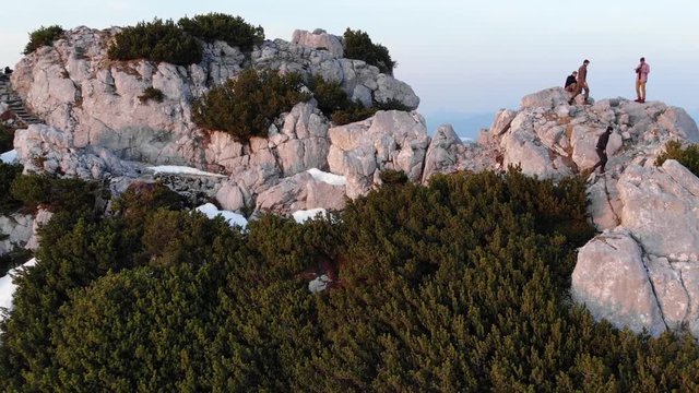 Mann geht entlang einer Felswand zum Gipfel zu den anderen Wanderern 