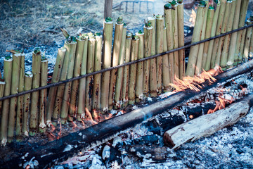 Burning  Khao Lam , Glutinous rice roasted in bamboo joints or Khao Lam is Thai dessert.