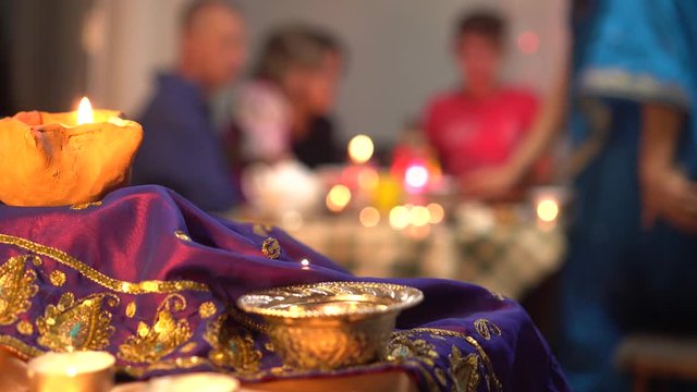 Indian traditional religious holiday. Hapy family dinner together at home. Festival food. Women in saris, children, husband, wife