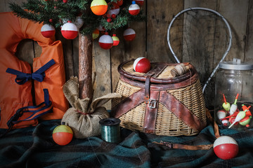 Christmas tree hung with brightly colored fishing bobbers with a fishing creel and net and life jacket © soupstock