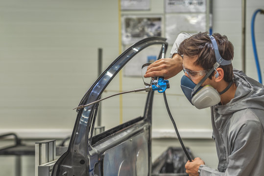 An employee of the paint shop of an automobile plant is trained to apply sealant