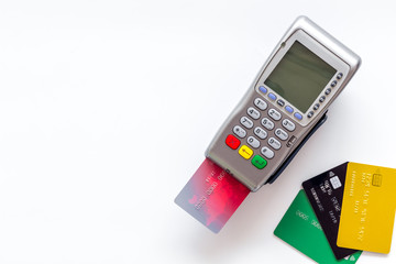 Pay by card. Plastic card inserted in terminal on white background top-down copy space