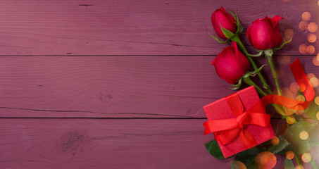 Naklejka na ściany i meble Valentines day card. Red gift box and roses on purple wooden table