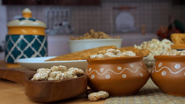 Tilt shot of delicious Lohri items served on the Punjabi's festival of Lohri in India. Closeup shot of groundnuts  popcorns  peanuts chikki  bhujia chikki  and rewri beautifully placed on a wooden ...