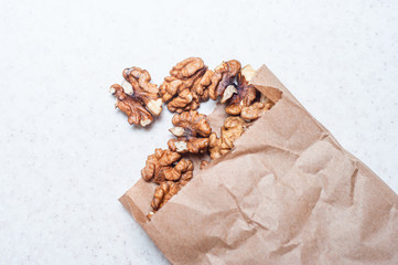 The daily rate of nuts for an adult in a paper bag on a white background. The benefits of walnut for the brain.
