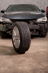Fototapeta na wymiar Photo of a car tire in the background of a car in the garage
