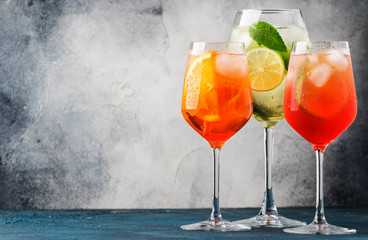 Set of summer Italian alcoholic cocktails, aperol spritz, martini royale, campari tonic with bitters and prosecco in misted wine glasses. Close-up,