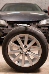 Close-up of new wheel to replace on old car in garage. Close up