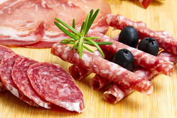 Meat and cheese plate antipasti snack with Prosciutto ham, Parmesan, Blue cheese, Cantaloupe melon and Olives on olive wood serving board on dark stone background