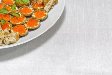 Sandwiches with red caviar on white plate close up with copy space
