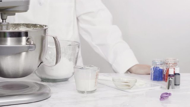 Step by step. Mixing ingredients in standing kitchen mixer to make buttercream frosting.
