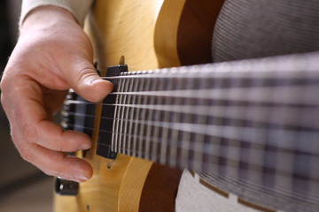 Male arms playing classic shape electric guitar