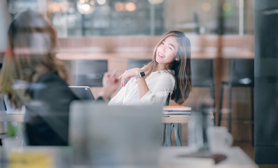 Shot of two businesswoman talking together with happiness while sitting in modern office.