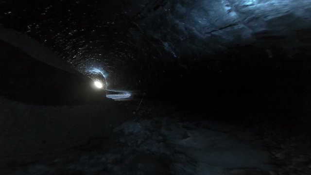 Walking through dark ice caves in Iceland glacier