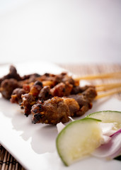 Satay, an Asian cusine set on a white plate