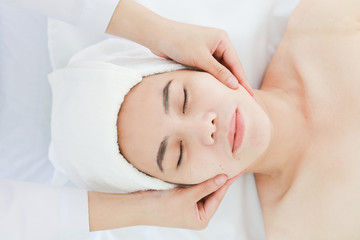 Obraz na płótnie Canvas Asian young woman getting spa treatment at beauty salon. spa face massage. facial beauty treatment
