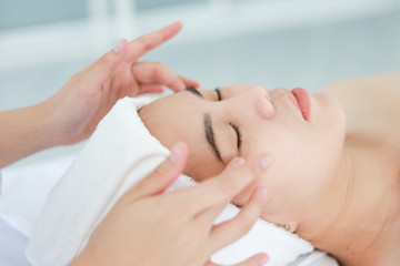 Fototapeta na wymiar Asian young woman getting spa treatment at beauty salon. spa face massage. facial beauty treatment