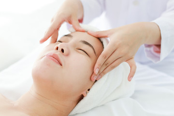 Fototapeta na wymiar Asian young woman getting spa treatment at beauty salon. spa face massage. facial beauty treatment