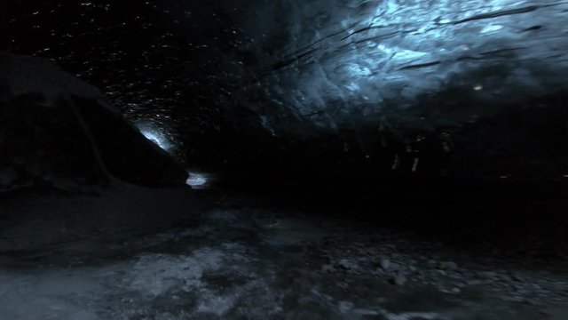 Walking through dark ice caves in Iceland glacier