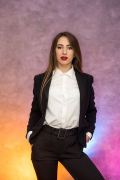 Business concept. Stylish businesswoman in elegant suit posing on abstract background