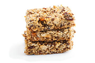 Homemade granola from oat flakes, dates, dried apricots, raisins, nuts isolated on white background. Side view.