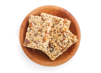 Homemade granola from oat flakes, dates, dried apricots, raisins, nuts in brown wooden plate isolated on white background. top view.