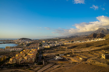 Spain, Tenerife, Aerial view above los christianos houses, a tourist resort city south of the island at the coast at sunset