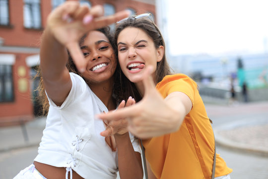 Cute young girls friends having fun together, taking a selfie at the city.