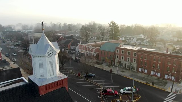Slow aerial parallax shot of white church steeple, tower, bells in small town America, Manheim, PA, USA