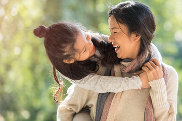 happy family on autumn walk. mother and daughter walking in the park and enjoying the beautiful autumn nature..family, children and happy people concept - hugging mother and daughter. © nareekarn